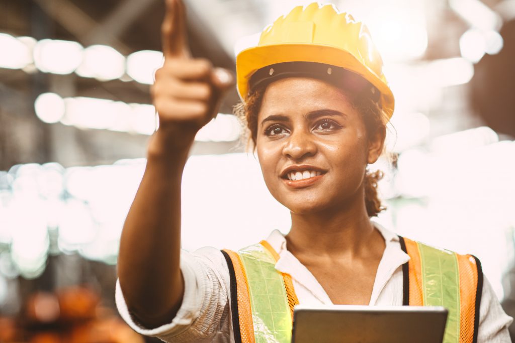 Smiling female engineer holding a tablet and gesturing
